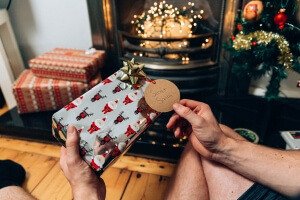 Christmas present by a fireplace