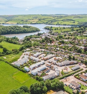 aerial picture showing houses, green fields and the coast in the background