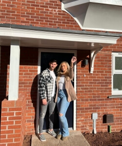 Nadia and Jordan in front of their new home