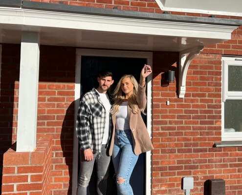 Nadia and Jordan in front of their new home