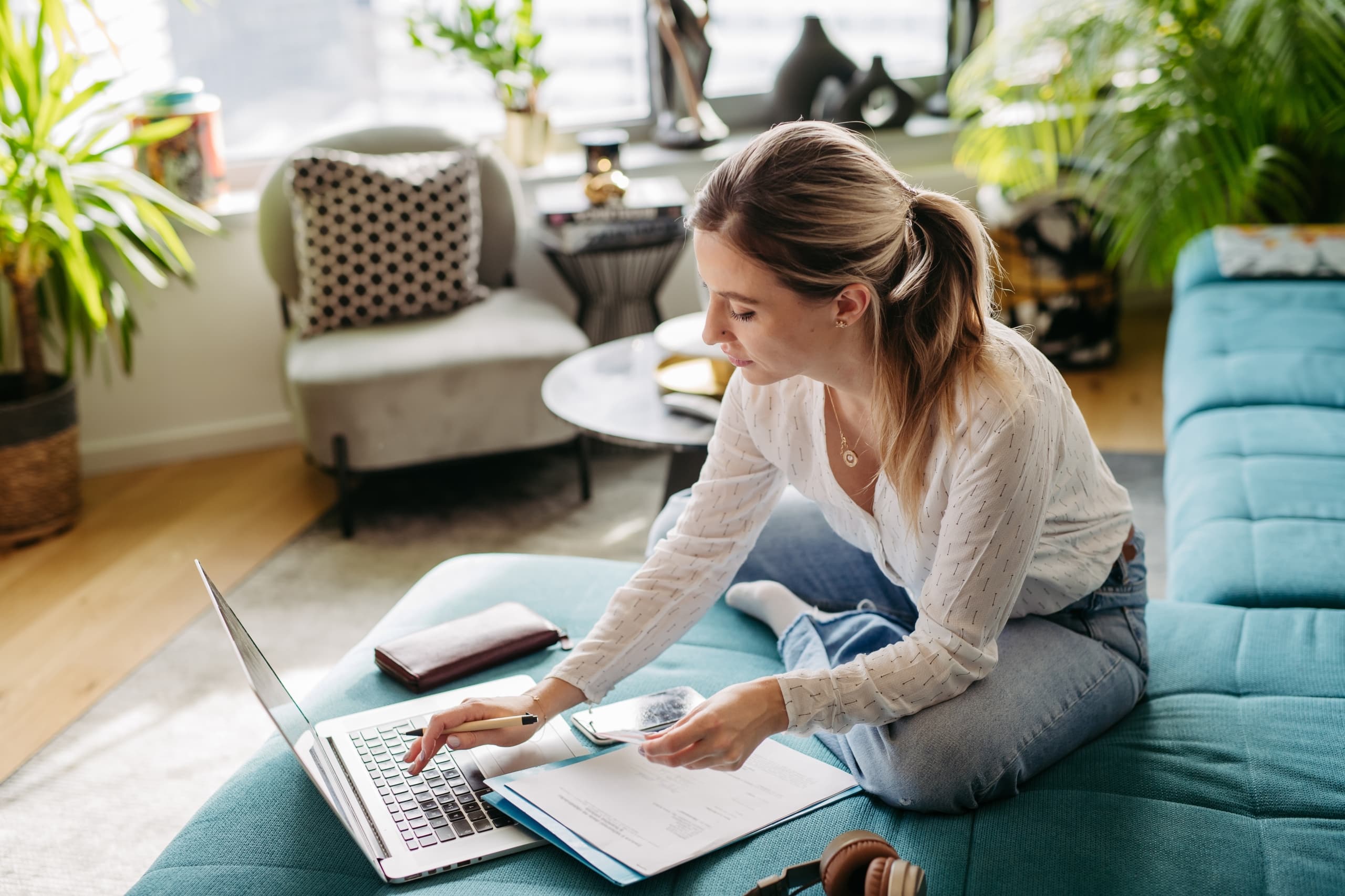 Woman,Paying,Bills,Online,,Sitting,In,Living,Room,,Working,On